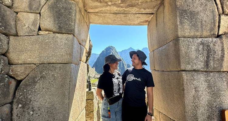 Deux personnes se tenant debout à l'intérieur d'une architecture de pierre ancienne.