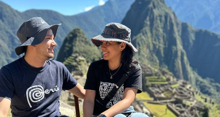 Couple souriant avec le Machu Picchu en arrière-plan.