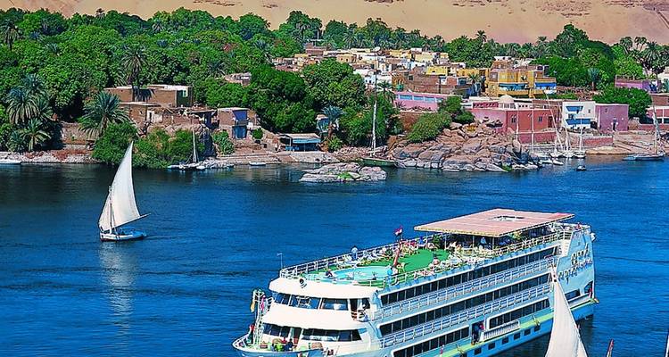 Bateau de croisière fluviale avec bâtiments colorés de la ville et dunes de sable.