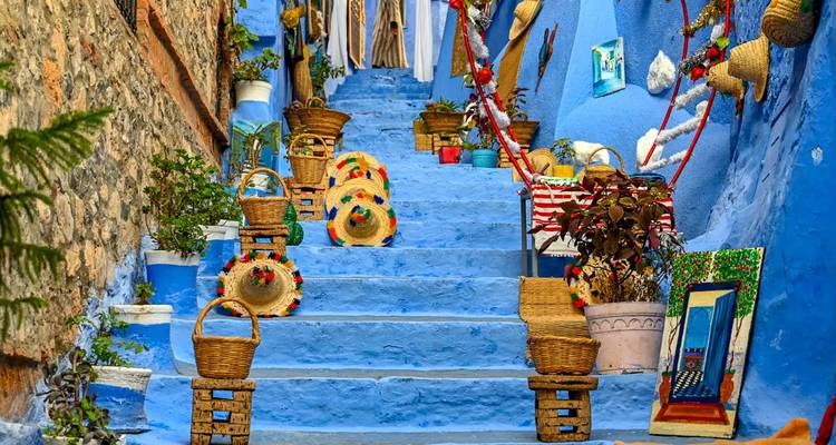 Escalera azul vibrante bordeada de cestas tejidas y artesanías en la medina de Chefchaouen