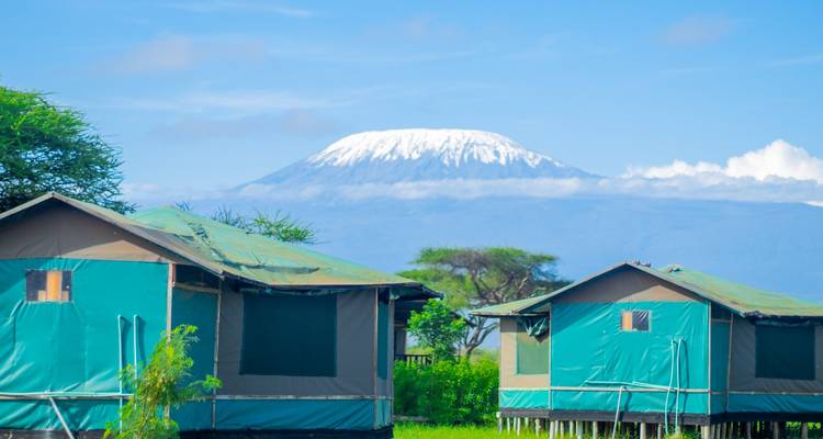 Camping tents with a mountain in the background under a clear blue sky.