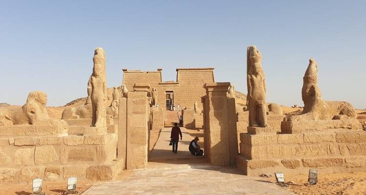 Ancient Egyptian temple with statues and tourists