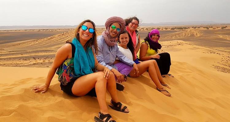 Un grupo de personas posando en las dunas de arena en Marruecos.
