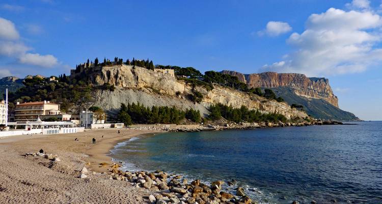 Beach and cliffs in Cassis with clear blue sky.