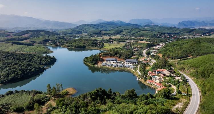 Panoramisch uitzicht op een serene meer met omliggende heuvels in Vietnam.