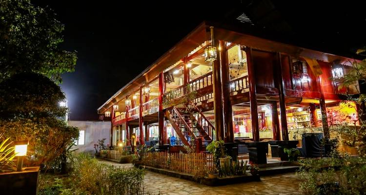 Nachtbeeld van een traditioneel gestyleerd huis met decoratieve verlichting in Vietnam.