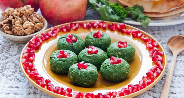 Un plato de bolas verdes tradicionales georgianas con semillas de granada.