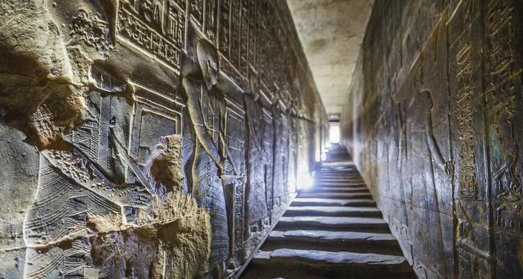 Alte Hieroglyphen an den Wänden eines schmalen Steingangs.