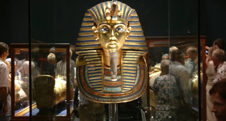 Tutanchamuns Maske in einem Museum mit Besuchern ausgestellt.