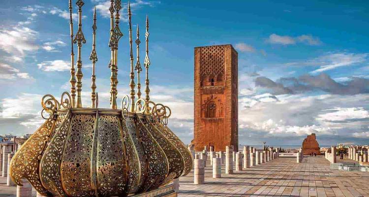 Intricate golden structure with a minaret and columns in the background.
