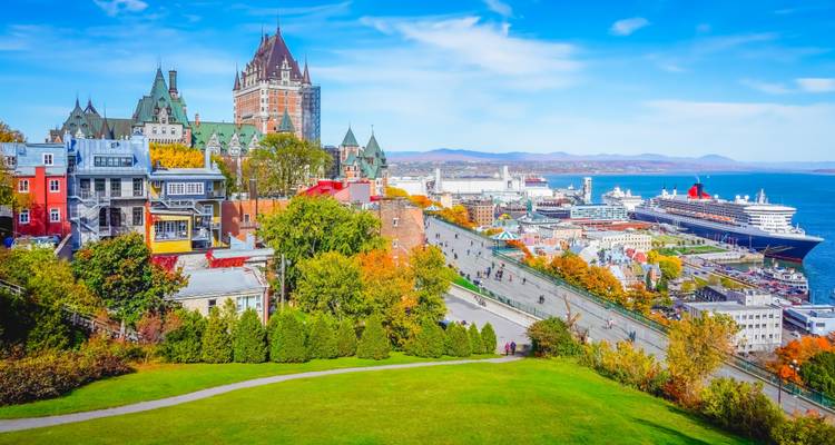 Panoramisch uitzicht op een historische stad met een groots kasteel nabij een rivier.
