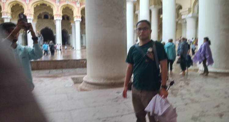 Imagen borrosa de personas dentro de un edificio histórico con columnas.