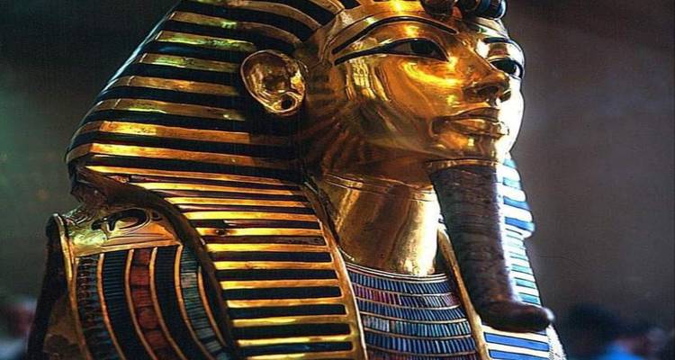 Gouden masker van een farao tentoongesteld onder zachte verlichting.