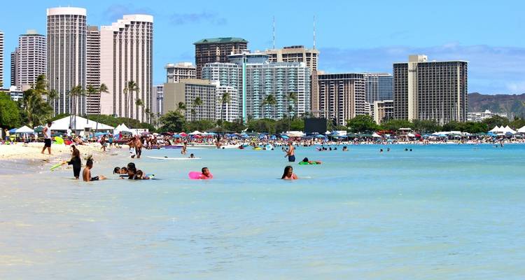 Crowded beach with skyscrapers in the background