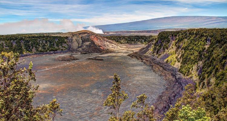 Volcanic crater with smoke and lush surroundings