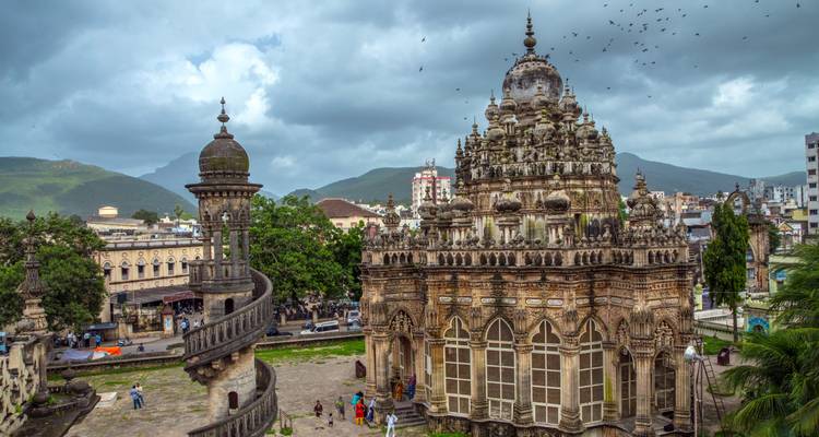 Monument historique avec des gens et un ciel nuageux.