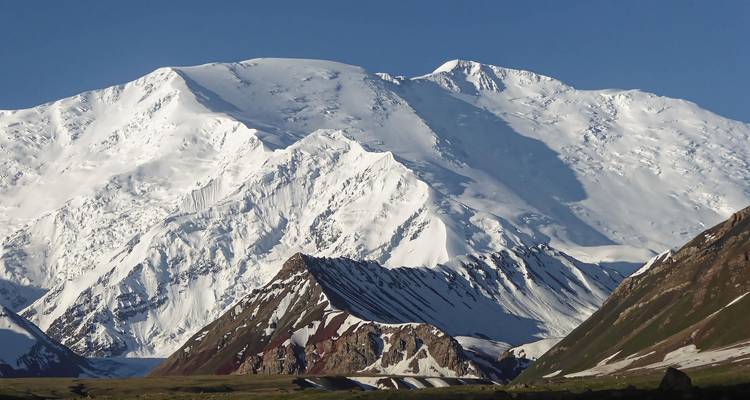 Chaîne de montagnes enneigée sous un ciel bleu dégagé.