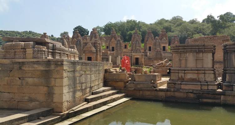 Traditional temple complex with statue and surrounding structures.