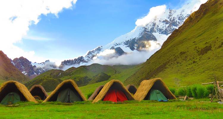 Bergcamping met besneeuwde toppen op de achtergrond.