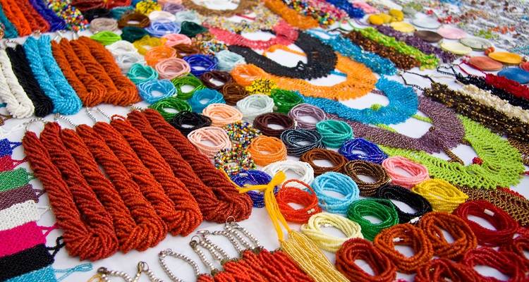 Kleurrijke handgemaakte sieraden en draden uitgestald op een markttafel.