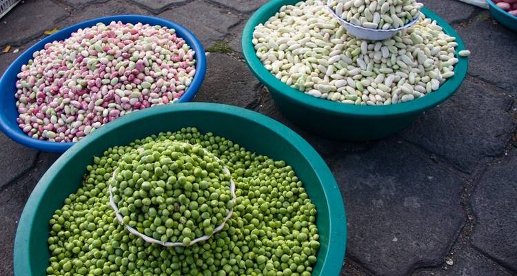 Kommen met verschillende kleurrijke bonen op een marktgrond.