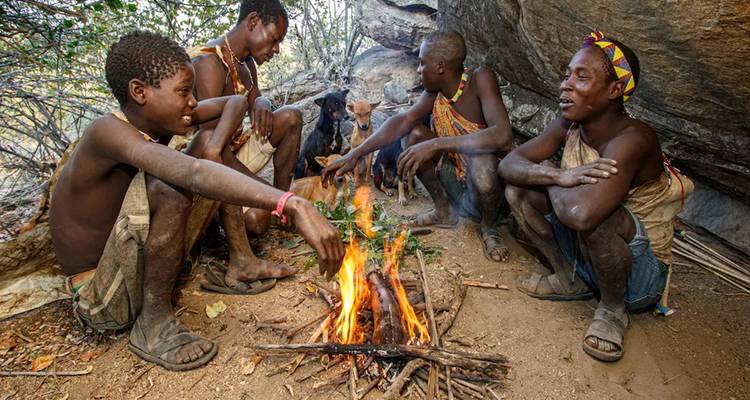 Eine Gruppe von Menschen, die um ein Lagerfeuer sitzen.