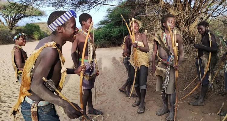 Menschen in traditioneller Kleidung mit Pfeil und Bogen.