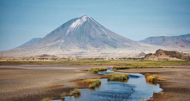 Malerische Aussicht auf einen kegelförmigen Berg mit einem Bach im Vordergrund.