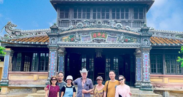Group of people posed in front of a traditional Vietnamese building.