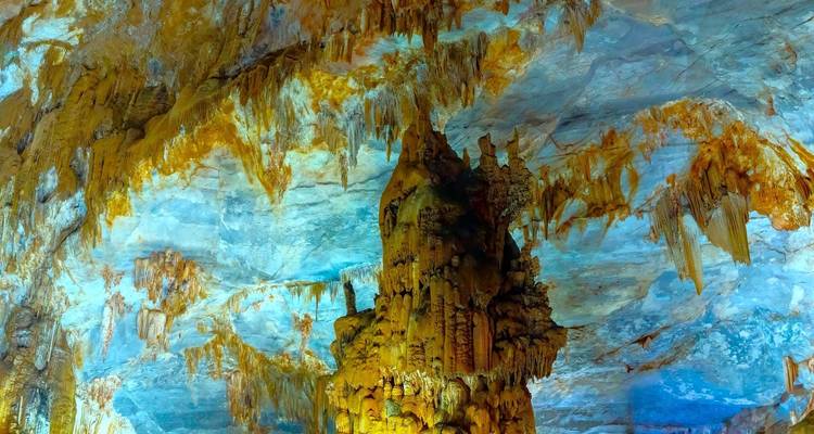 Stalactites et stalagmites colorées dans une grotte.