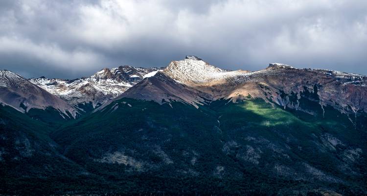 Cieux orageux au-dessus d'une chaîne de montagnes escarpée.