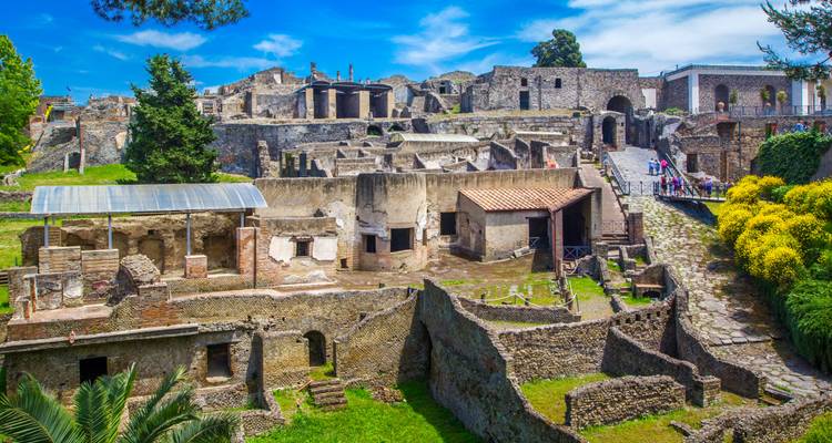 Ruinas arqueológicas con visitantes explorando en Pompeya.