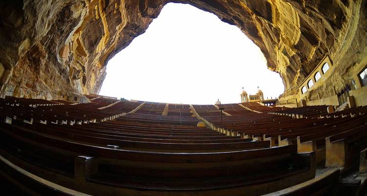 Rotsgehouwen amfitheater met een heldere hemel erboven.