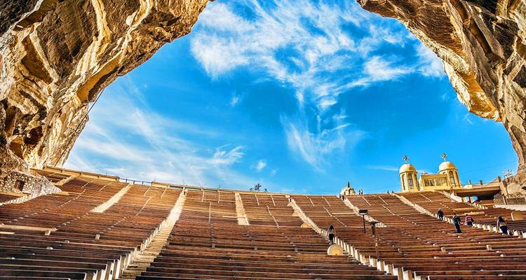Antiek amfitheater met blauwe luchten en sierlijke structuren.