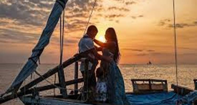 Silhouetten von Menschen auf einem Boot während des Sonnenuntergangs.