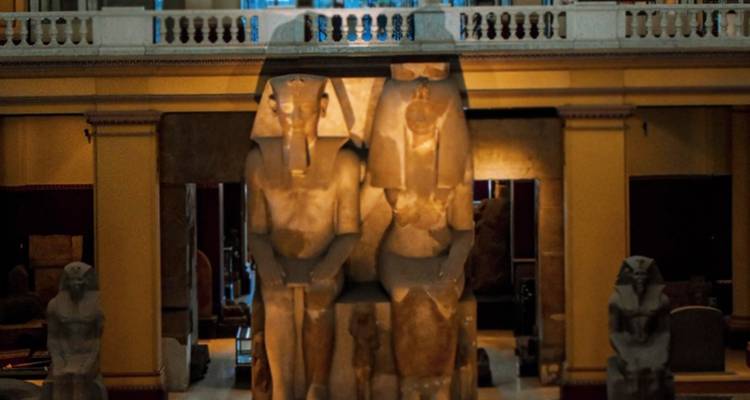 Interieur van een museum met oude beelden.