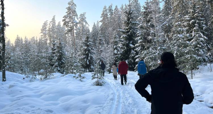 Mensen die door een besneeuwde boslandschap lopen.