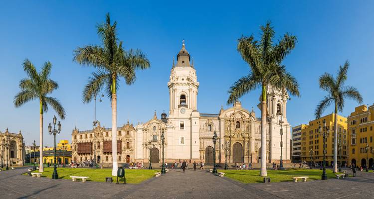 Hauptplatz in Lima mit einer historischen Kathedrale und Palmen.