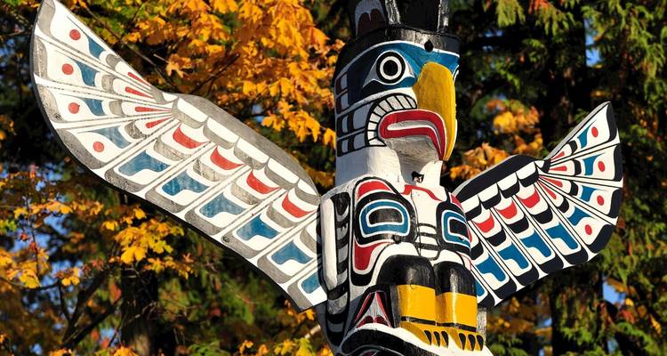 Totem coloré avec feuillage d'automne en arrière-plan.