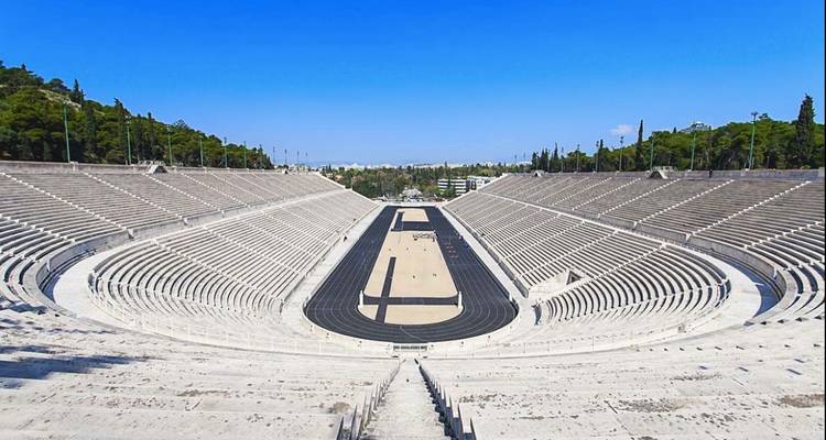 Panathenaic Stadium with empty stands under a clear blue sky.