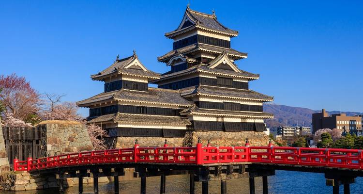 Matsumoto Kasteel met een rode brug op de voorgrond.