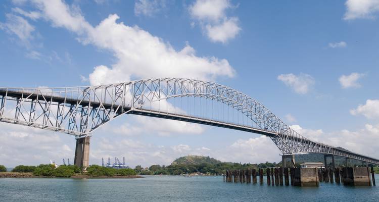 L'arche d'acier du Pont des Amériques enjambe le Canal de Panama sous un ciel bleu éclatant.