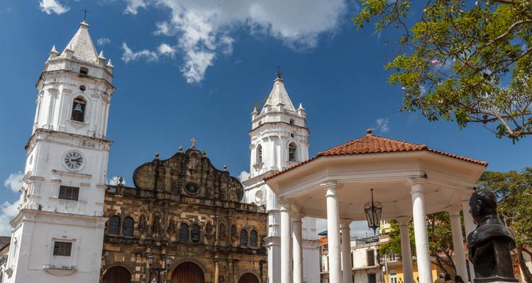 Las torres de la catedral histórica blanca y la glorieta en el Casco Viejo colonial de la Ciudad de Panamá bajo un cielo brillante.