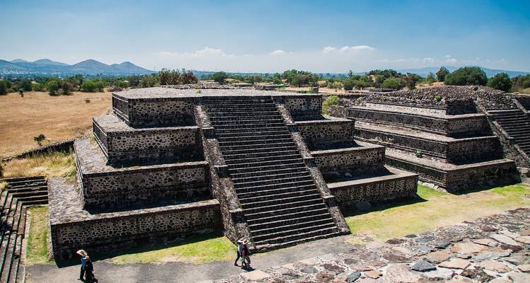 Plataformas de piedra escalonadas de las pirámides de Teotihuacán bajo un cielo azul brillante.