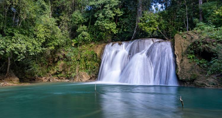 Exuberante cascada de la selva cayendo en una piscina color turquesa en la selva tropical de Chiapas.