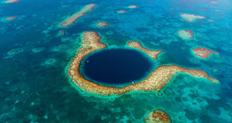 Vista aérea del profundo Gran Agujero Azul circular rodeado de arrecifes de coral