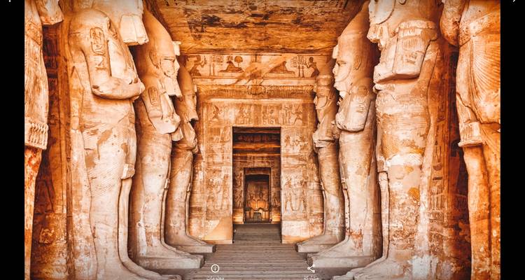 Pasaje interior de un templo revestido con estatuas masivas y tallas.