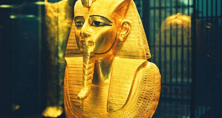 Gouden masker van een oude Egyptische farao in een museumomgeving.