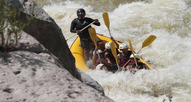 Grupo de personas practicando rafting en un río.