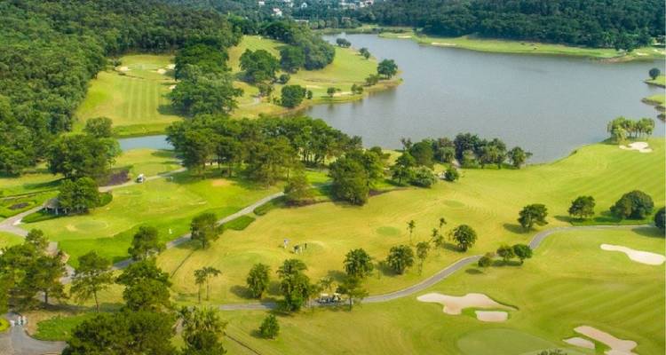 Luchtfoto van een golfbaan met weelderig groen en een groot meer.